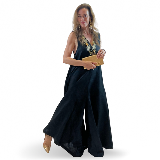 Woman in a black linen maxi romper featuring a V-neck, sleeveless cut, and elegant boho silhouette.
