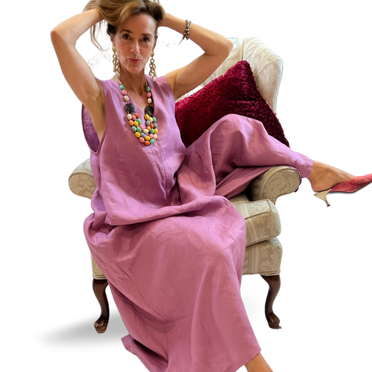 Model wearing a pink sleeveless linen maxi romper with V-neckline, pockets, and zip-back closure